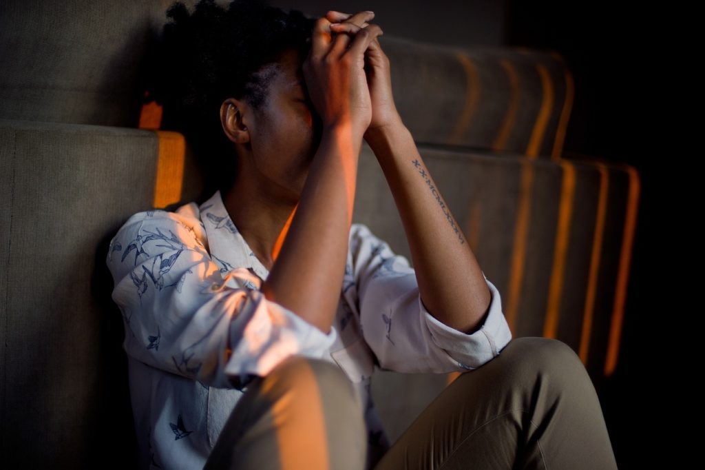 Femme pensive regardant par la fenêtre - impression de vivre la vie de quelqu'un d'autre